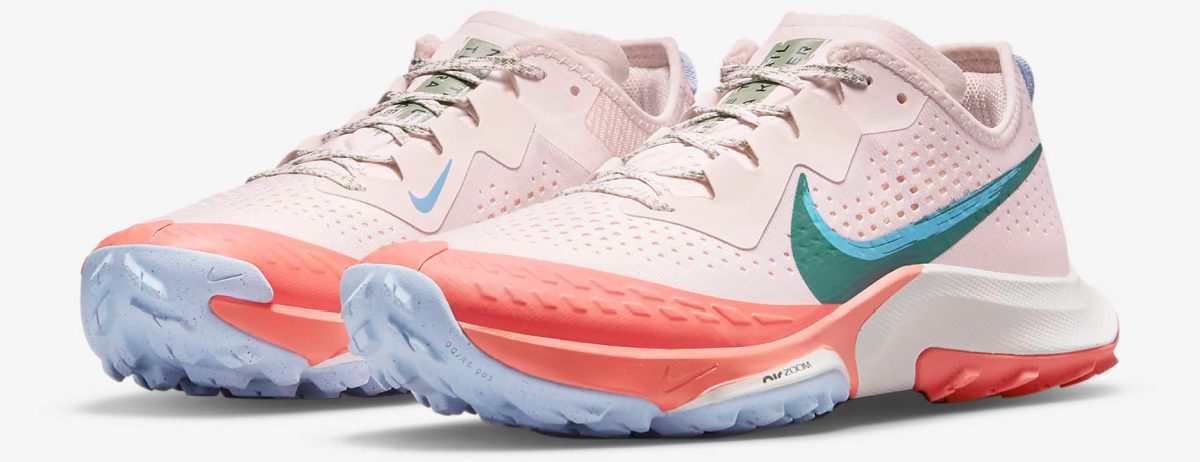 pink sneakers with a blue nike swoosh