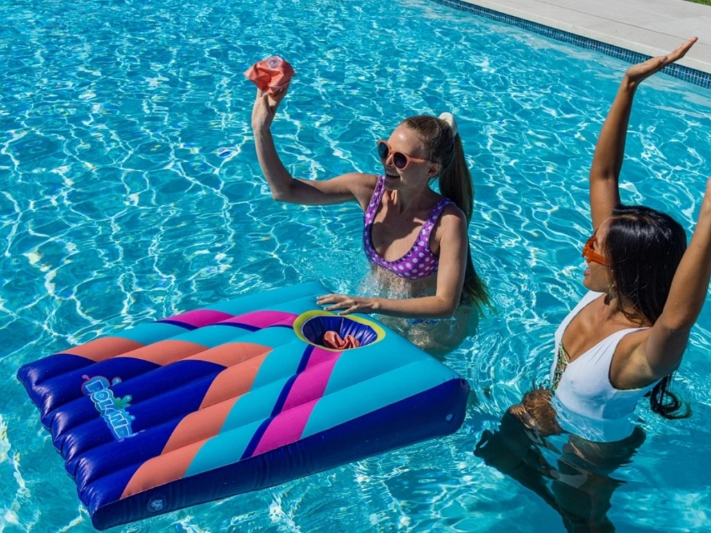 girls playing poolcandy inflatable cornhole toss in pool