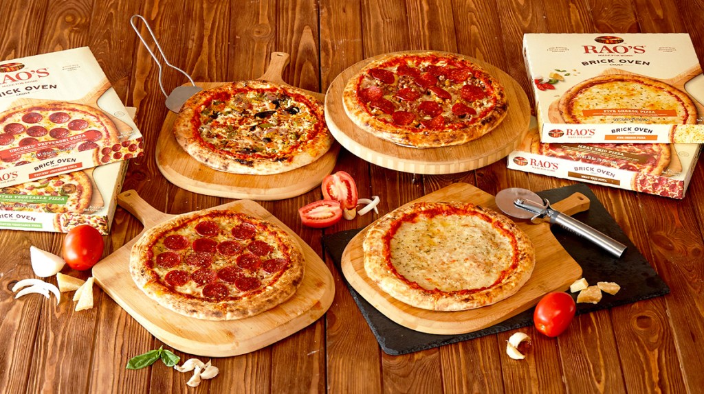 بيتزا راو المجمدة وصناديق على طاولة خشبية ومجداف البيتزا
