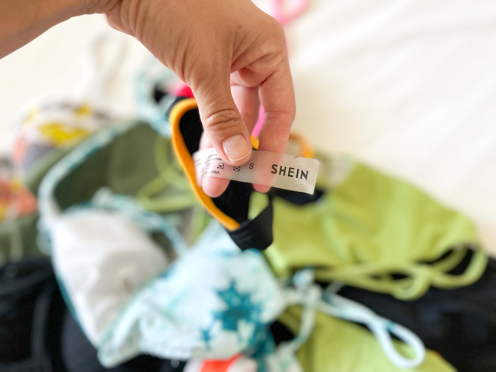 holding bathing suit with Shein tag 