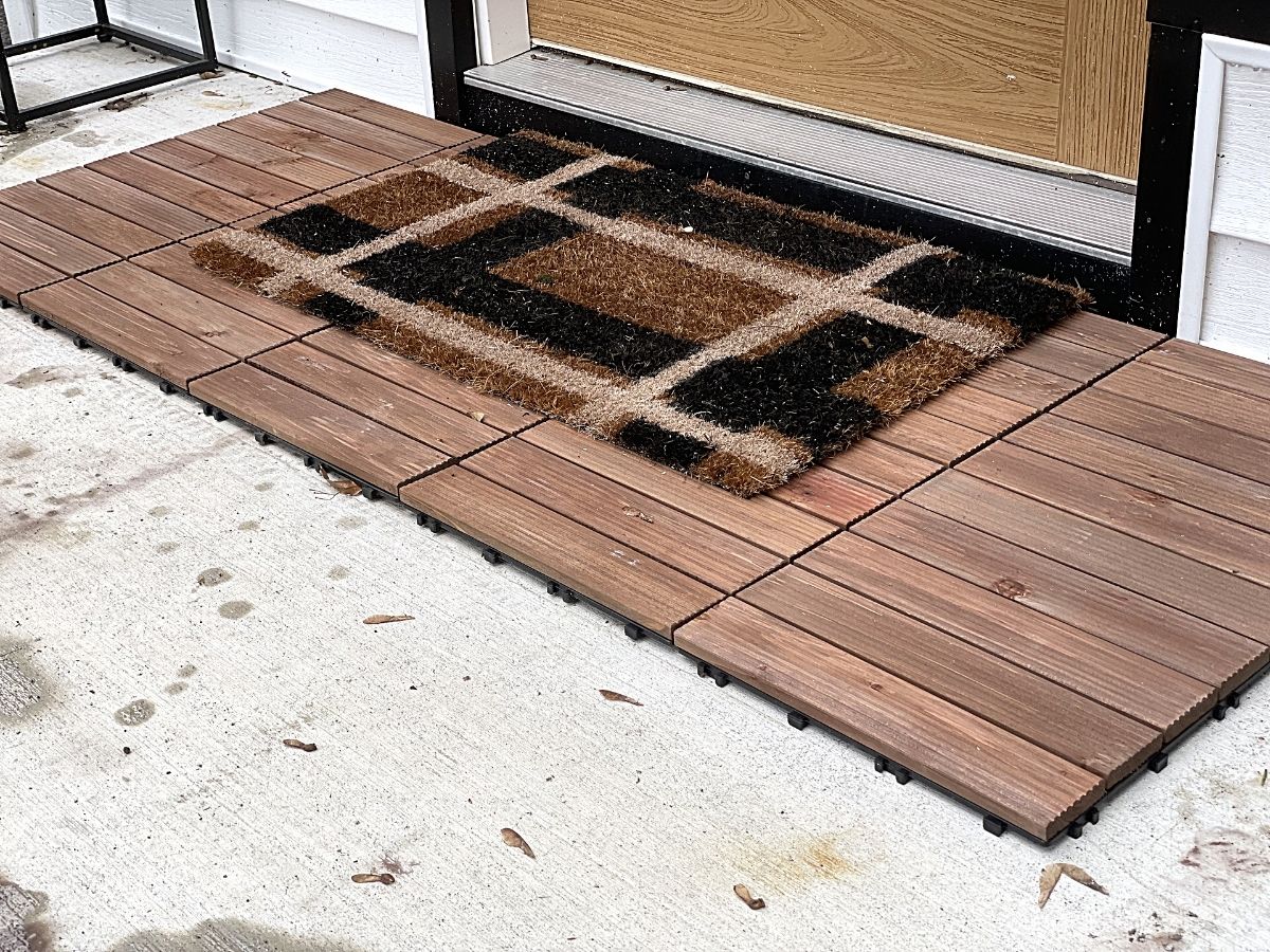 wood tile on front porch with rug laying on it