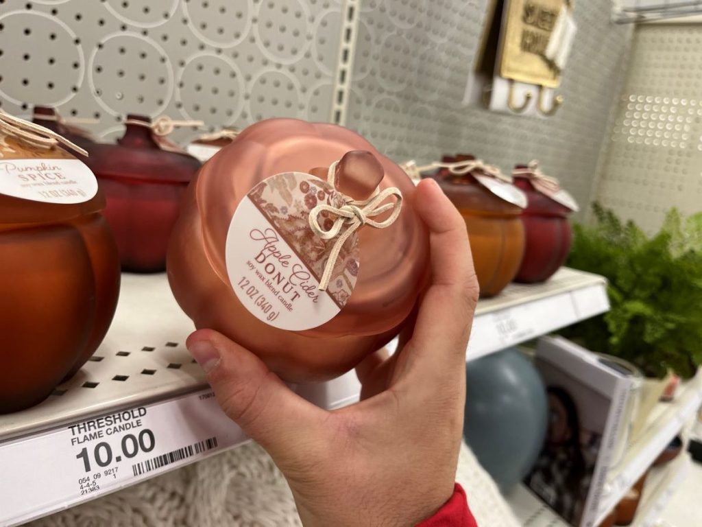 hand holding a pumpkin jar candle