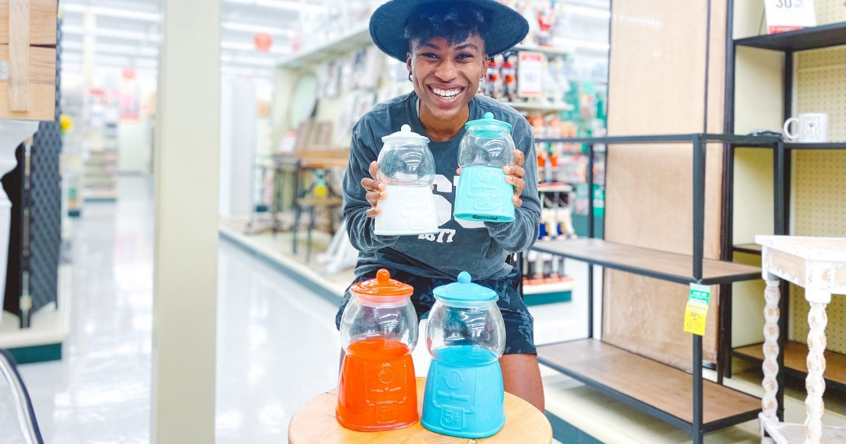 woman holding different colored vintage gumball machines in store