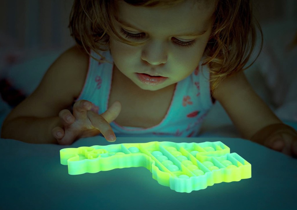 girl playing with glowing pop it toy 