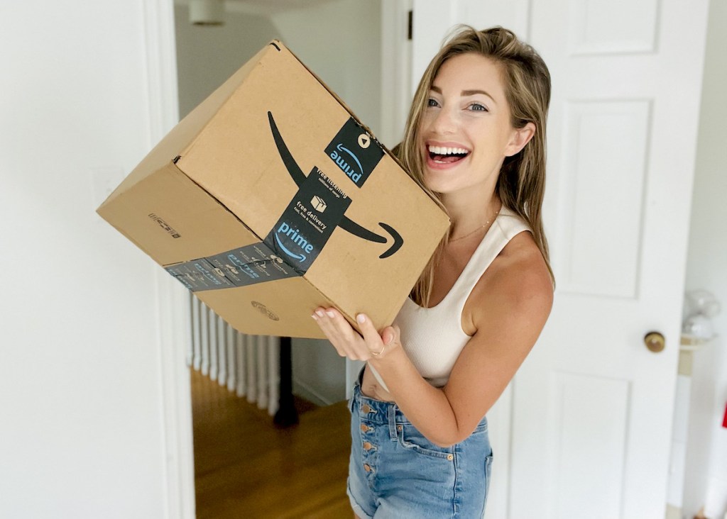 woman smiling holding up amazon prime box