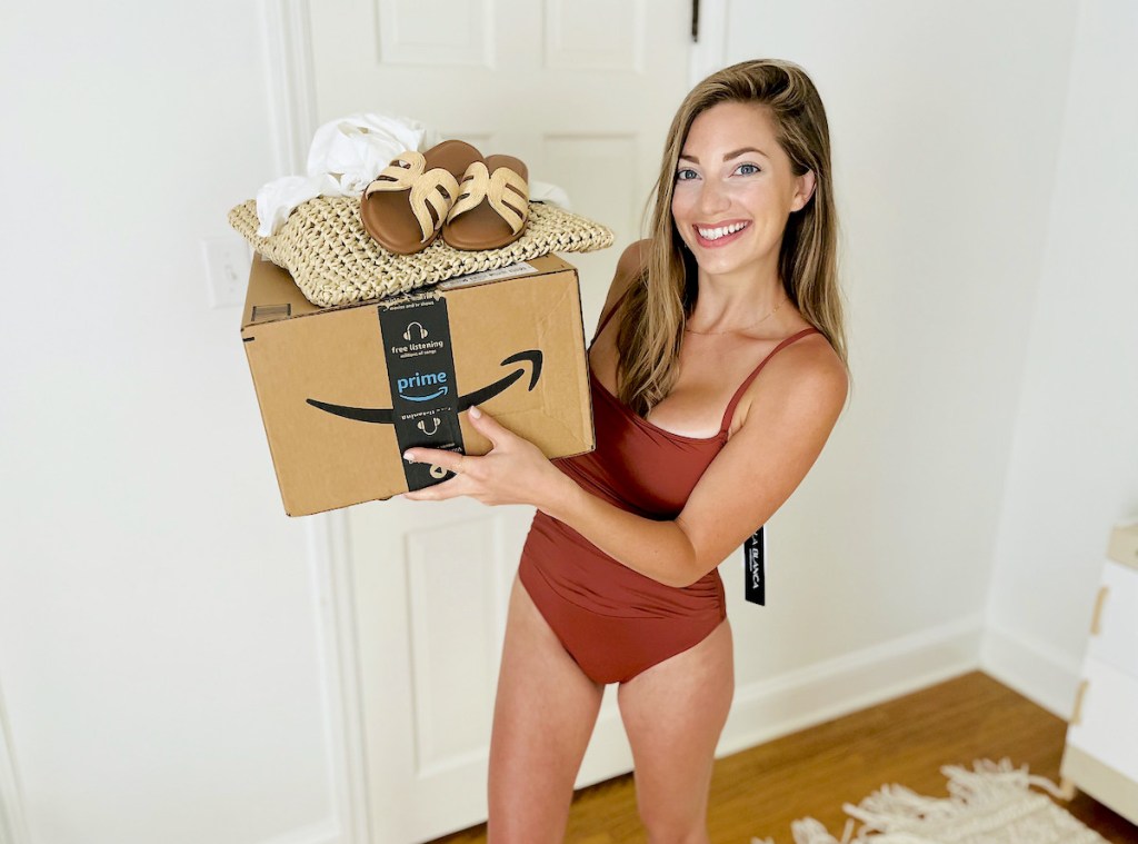 woman wearing red bathing suit holding up box of clothes