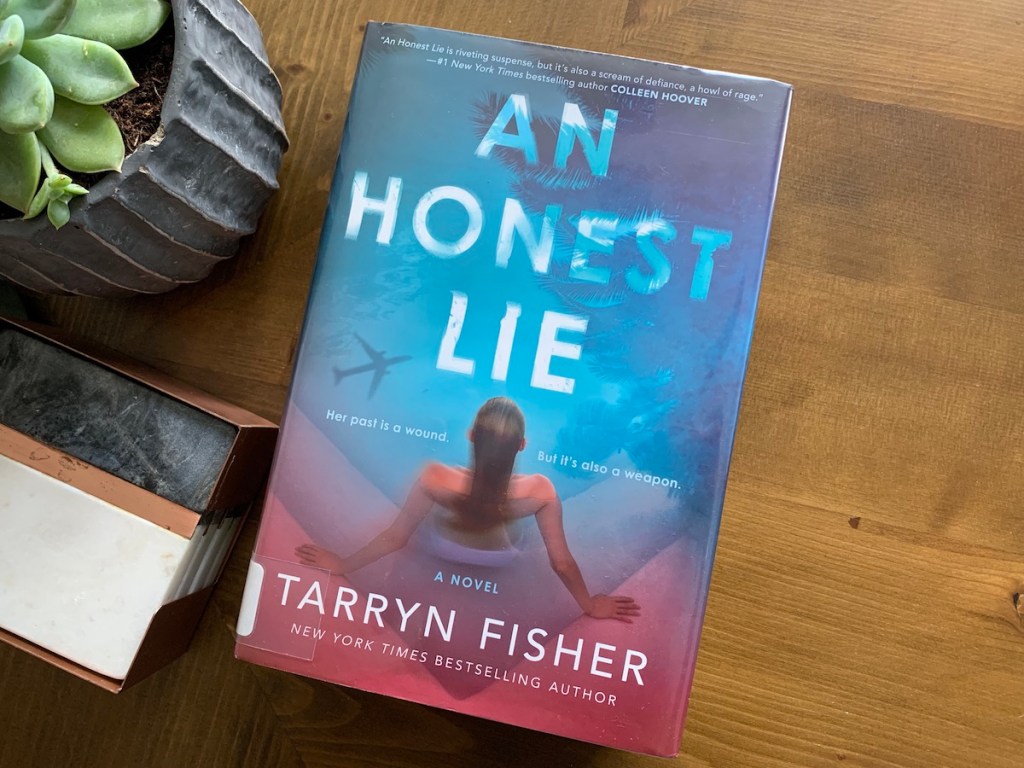 an honest lie book on wood table next to plant