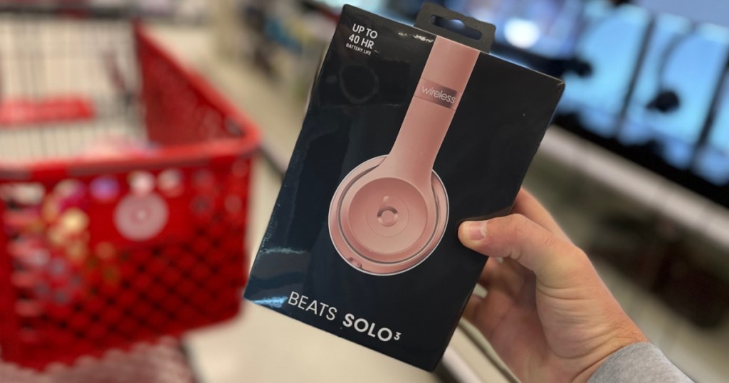 hand holding pink headphones 