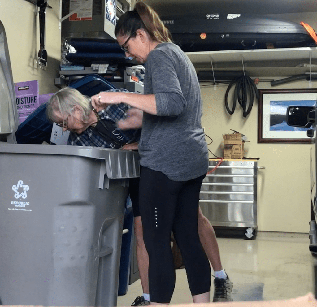 two women in trash can sitting in garage