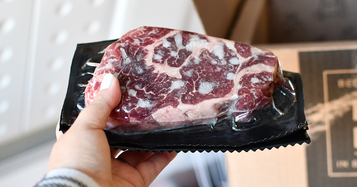 hand holding frozen ribeye