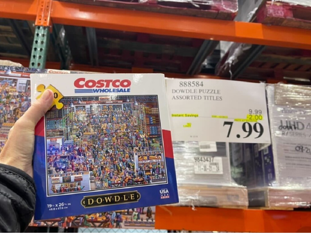 hand holding puzzle next to store sale price sign