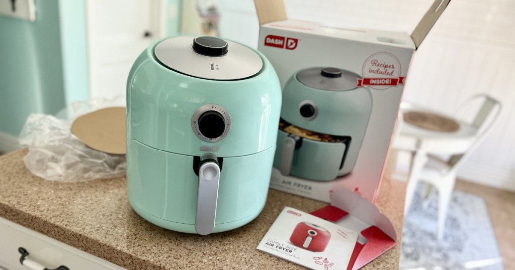 dash air fryer on table with packaging and manual