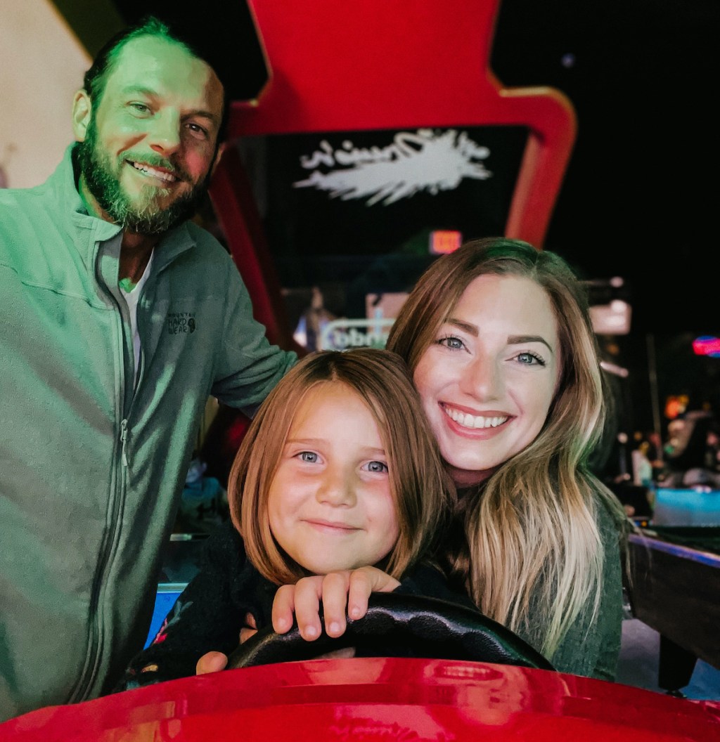 people sitting in race car arcade game