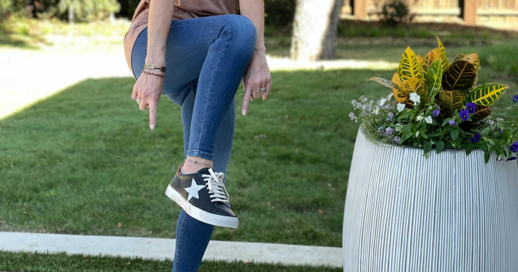 woman pointing to black sneakers