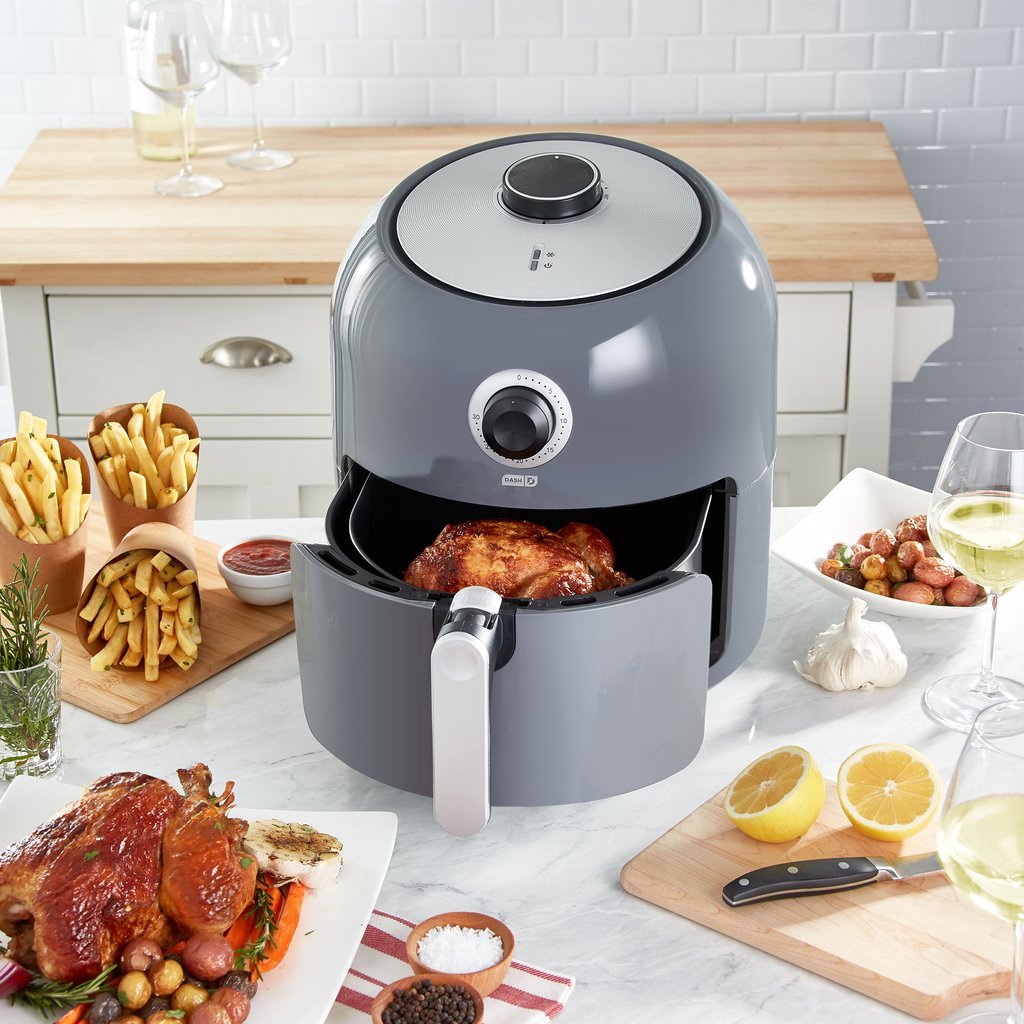 grey air fryer in kitchen with food on counter 