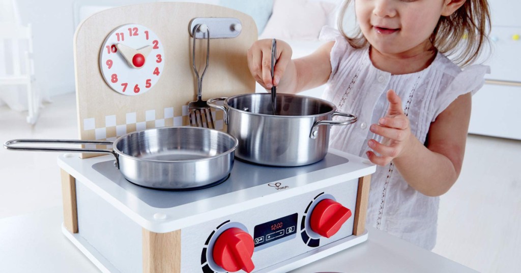 girl playing with hape 2in1 kitchen