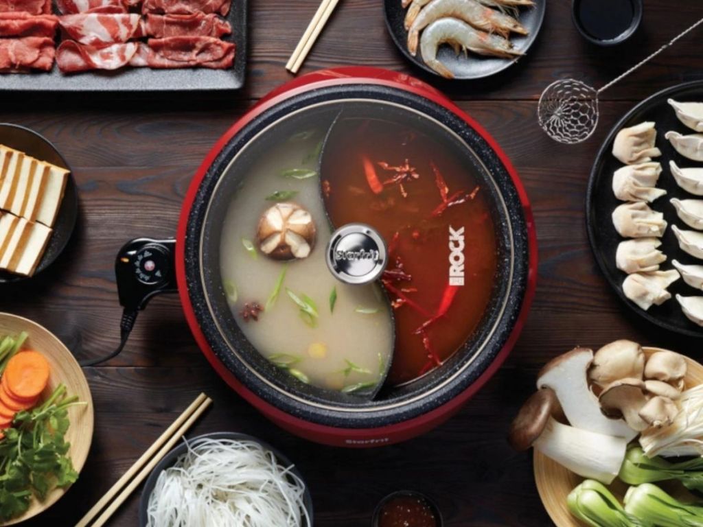 hot pot with food in it and surrounding it