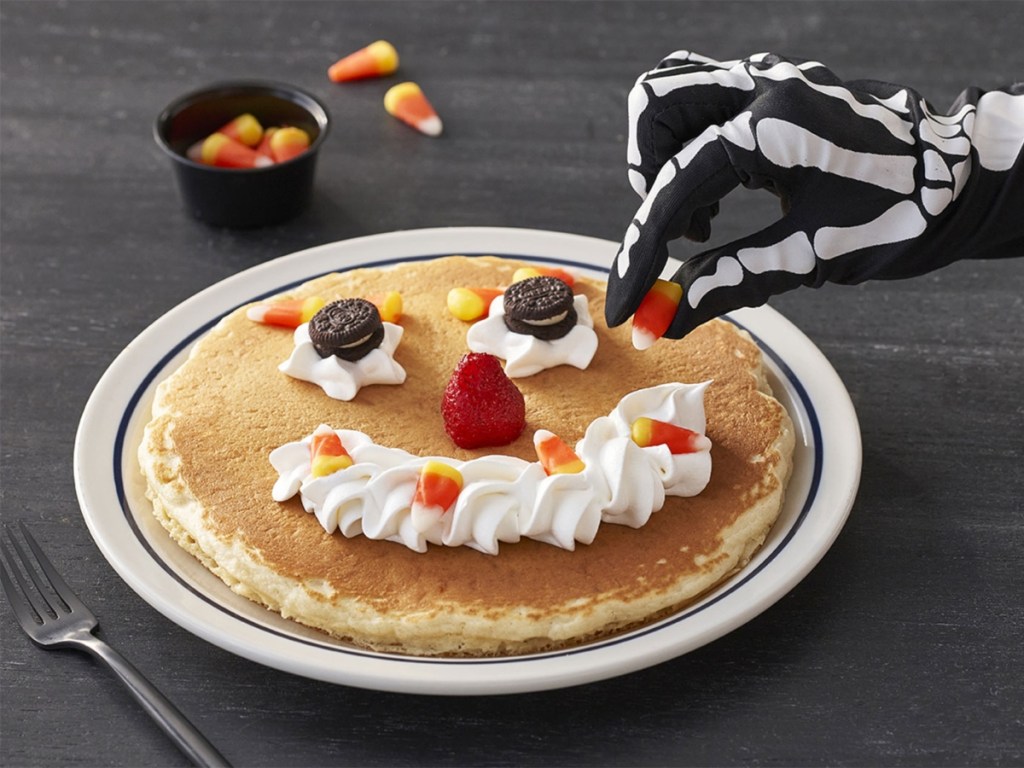 skeleton hand topping a pancake with candy corn