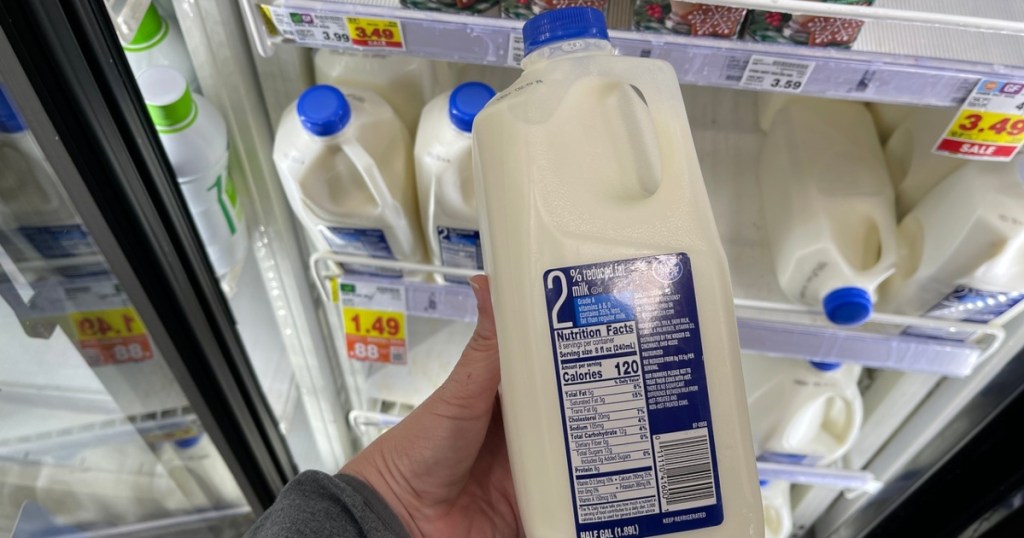 holding a half-gallon of 2% milk