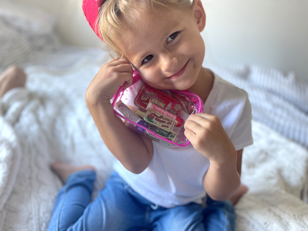 little girl holding tinte cosmetics lip gift set 