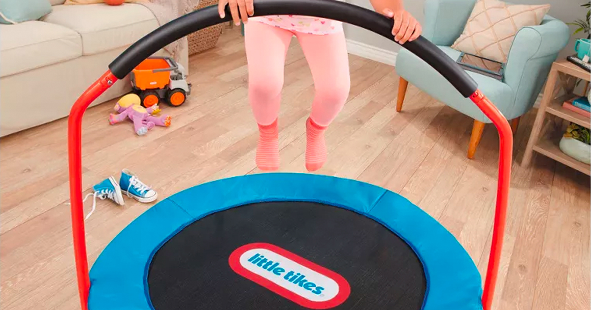 young girl jumping on a little tikes easy store trampoline in a living room with furniture and toys
