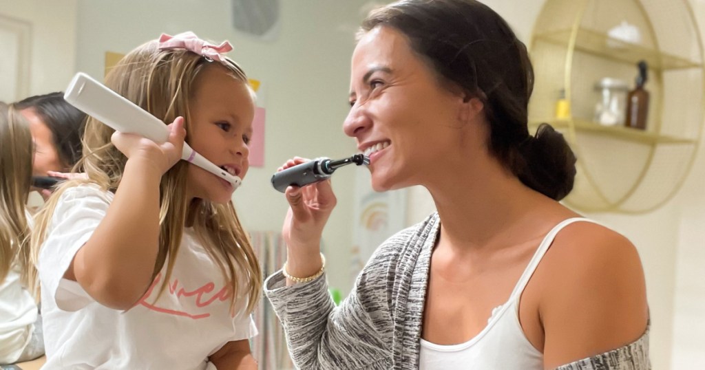 mom +daughter brushing teeth w/ oral-b