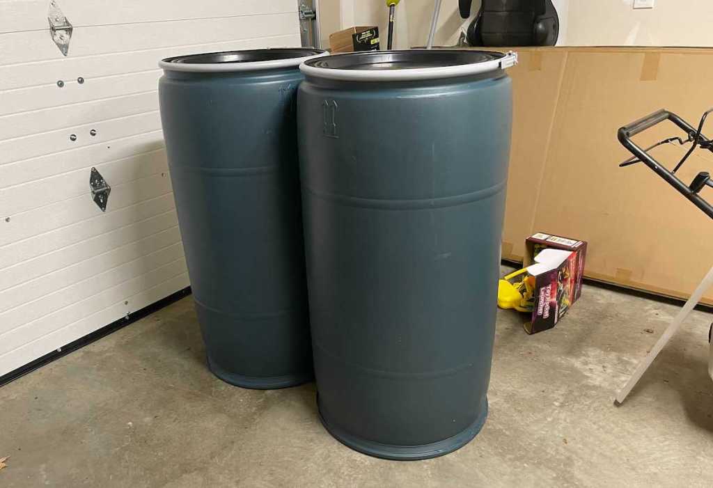 two blue plastic barrels sitting on garage floor