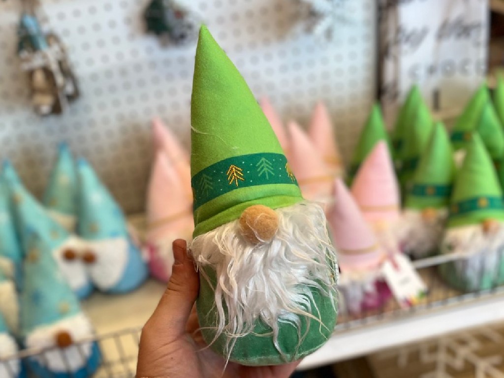 hand holding green plush gnome by store display