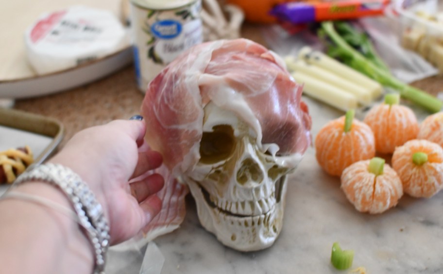 making a prosciutto covered skull for a spooky charcuterie board