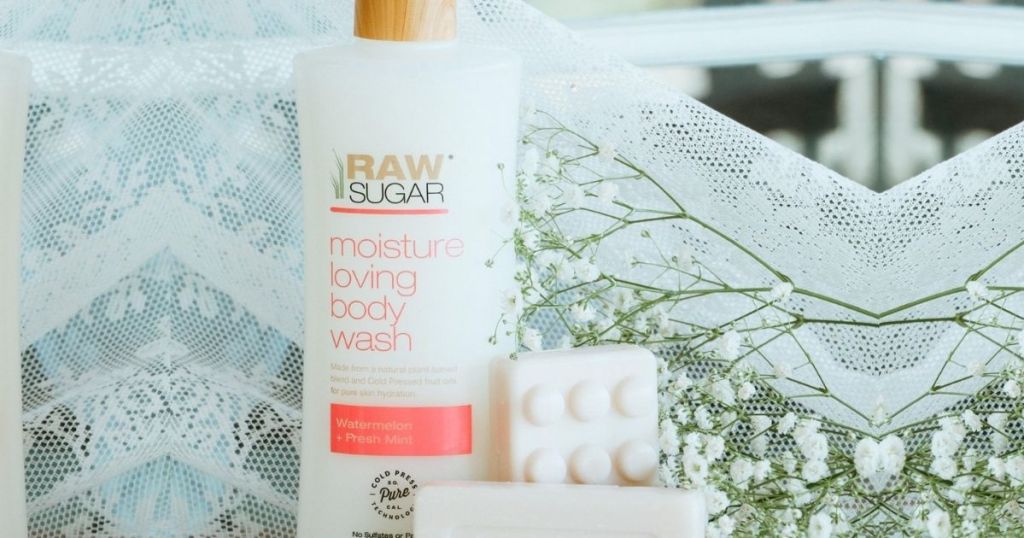 Raw Sugar body wash next to soap, flowers and lace