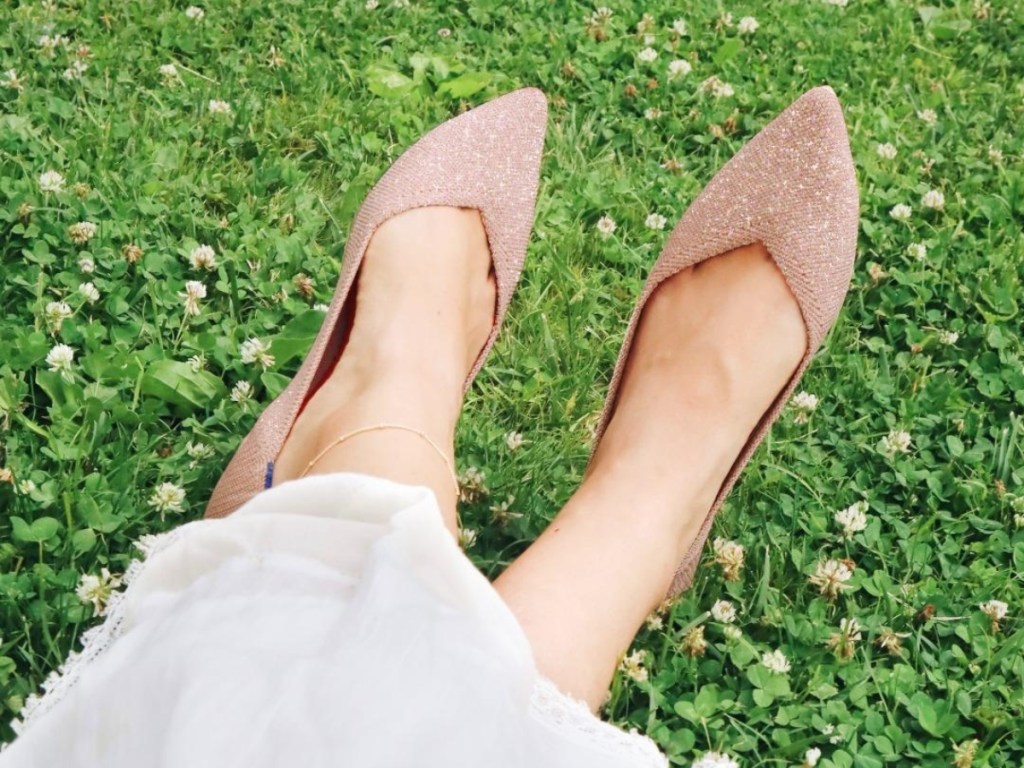 wearing a pair of tan pointed-toe flats