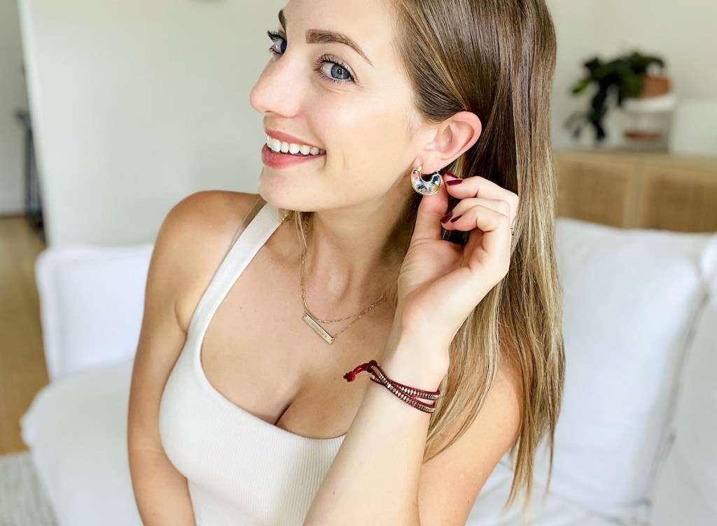 woman showing off hoop earrings smiling