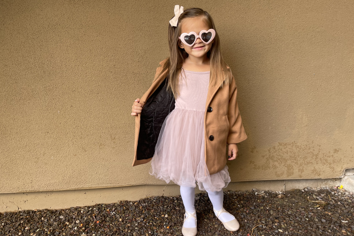 girl in pink dress and tan coat