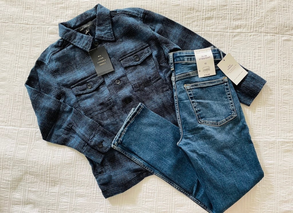blue and black flannel and jeans laying on white bed