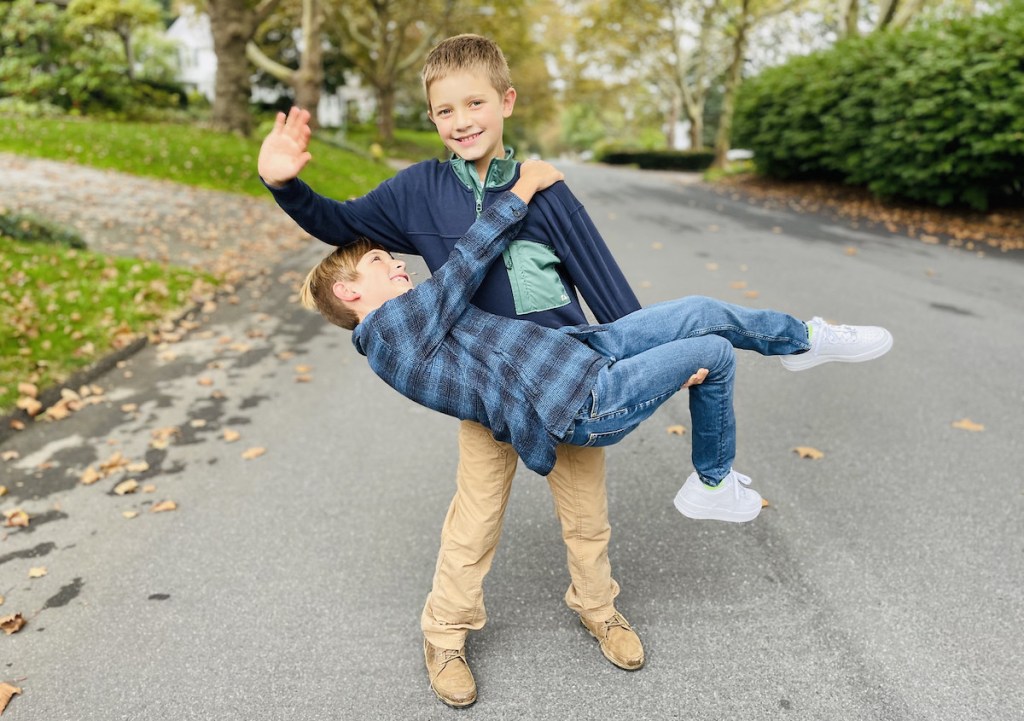 two boys standing in street goofing off 