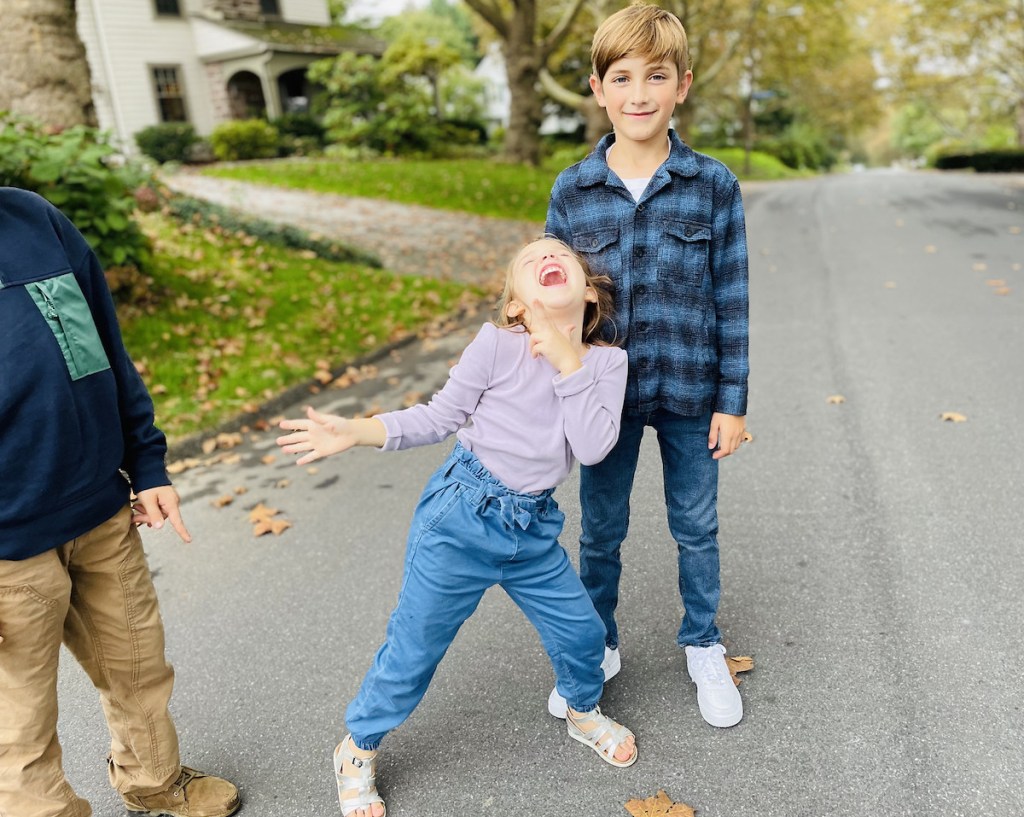 girl and boy standing in street being silly