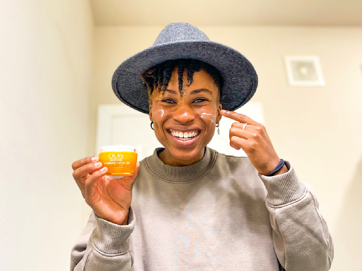 woman holding a jar of Olay Vitamin C + Peptide Face Moisturizer