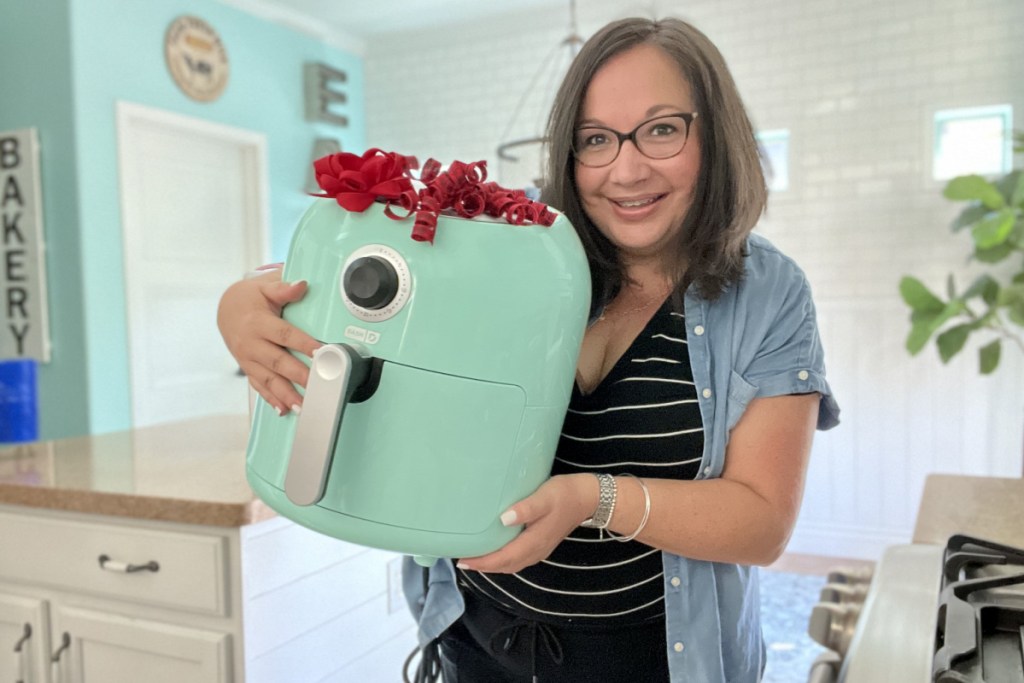 woman holding air fryer with bow on it