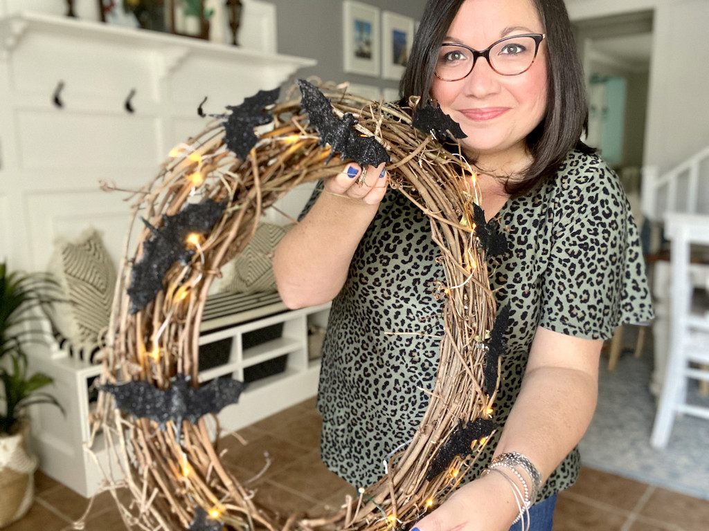 woman holding Halloween bat wreath 