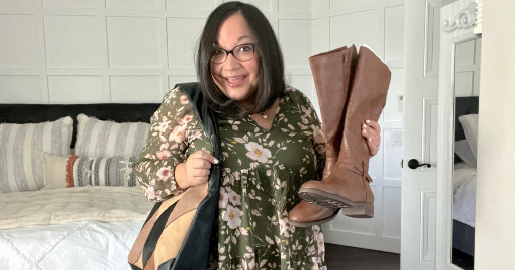 woman wearing fall dress and holding riding boots 