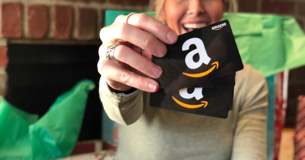 Frau hält 2 Amazon-Geschenkkarten