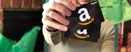 Woman holding 2 amazon gift cards