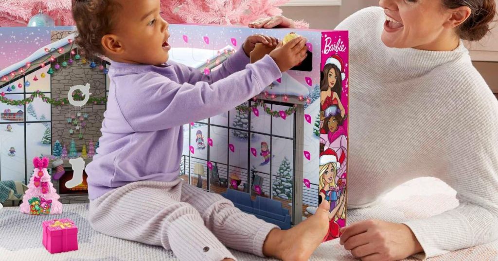 A small child playing with a Barbie Advent Calendar