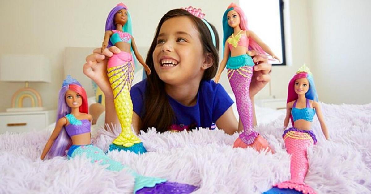 girl playing with barbie mermaid dreamtopia dolls