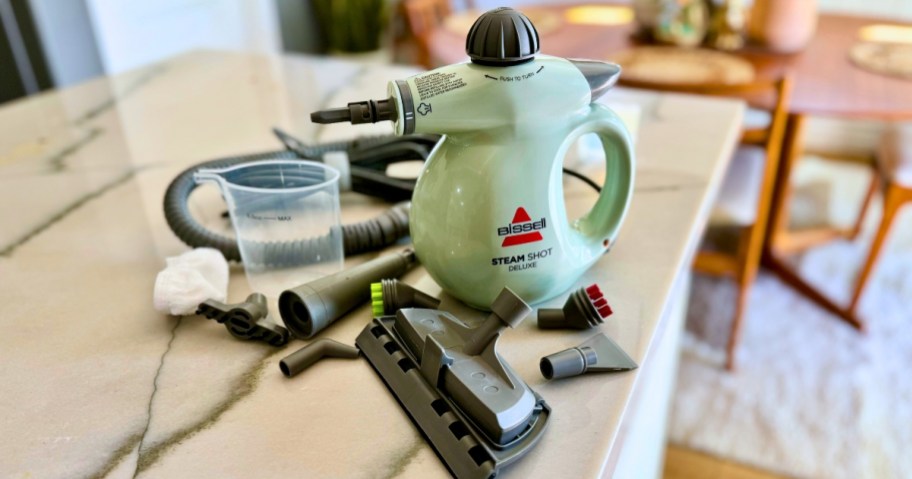Bissell SteamShot cleaner with accessories and attachments on counter