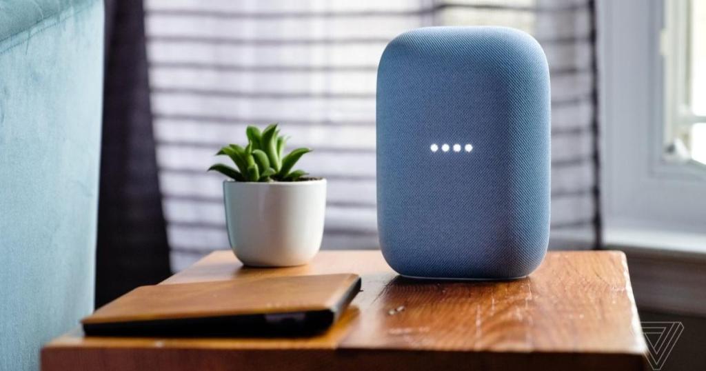blue google nest audio sitting on end table with plant