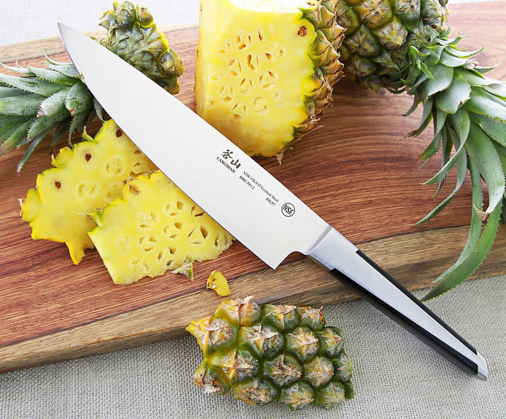 chef knife with cutting board and pineapple