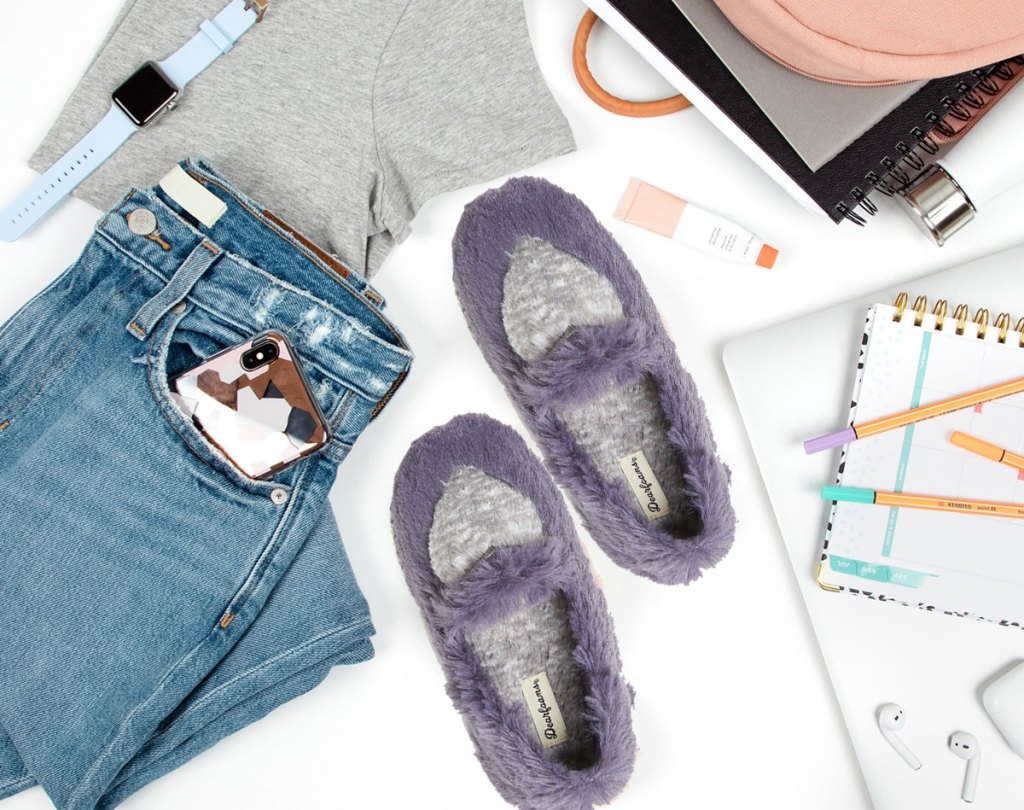 purple slippers next to jeans and notebooks