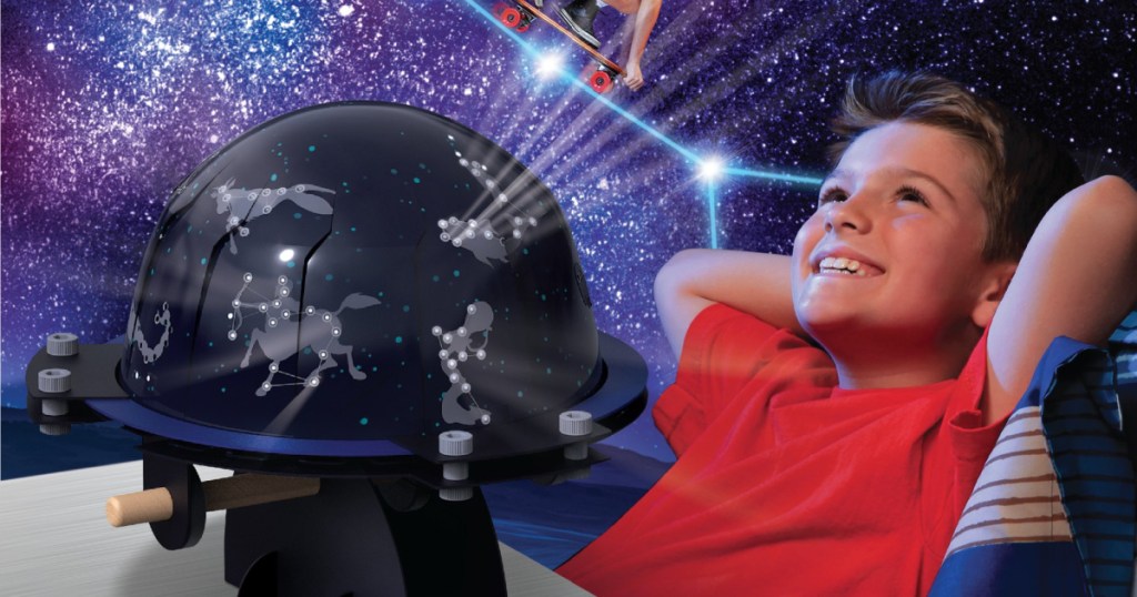 boy sitting next to a star projector