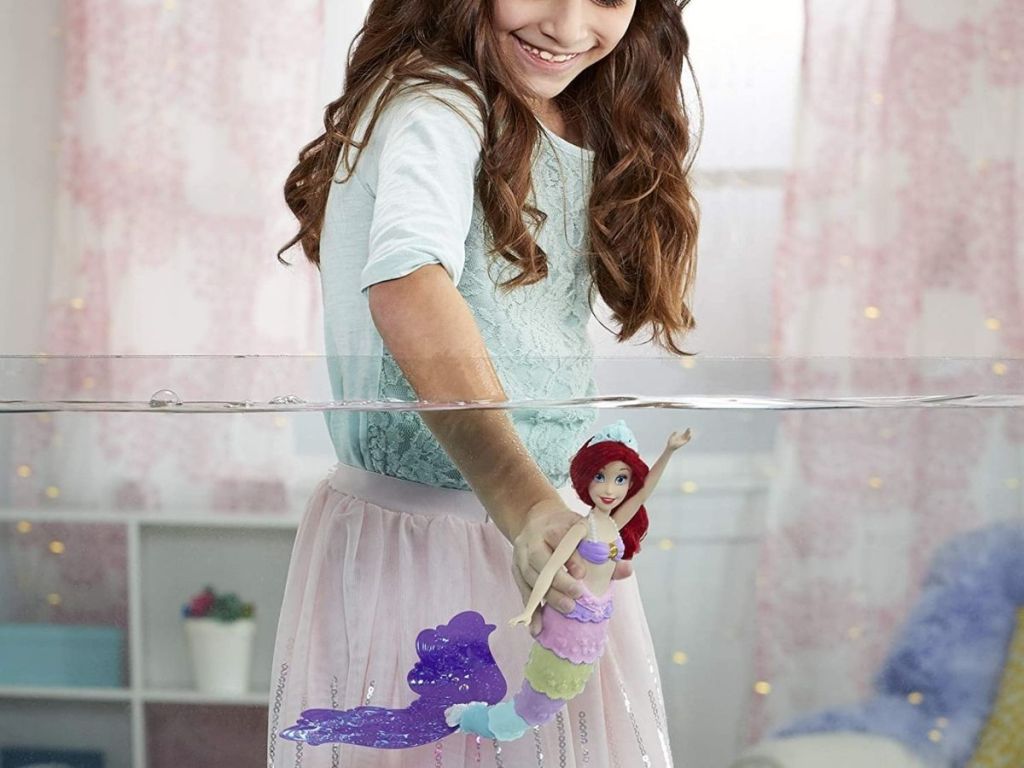 girl putting Ariel doll in water